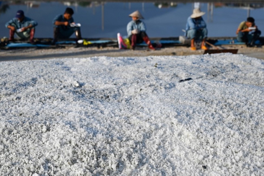 Workers take a break in front of harvested salt in southern Vietnamu00e2u20acu2122s Hon Khoi salt fields April 22, 2019. u00e2u20acu201d AFP pic