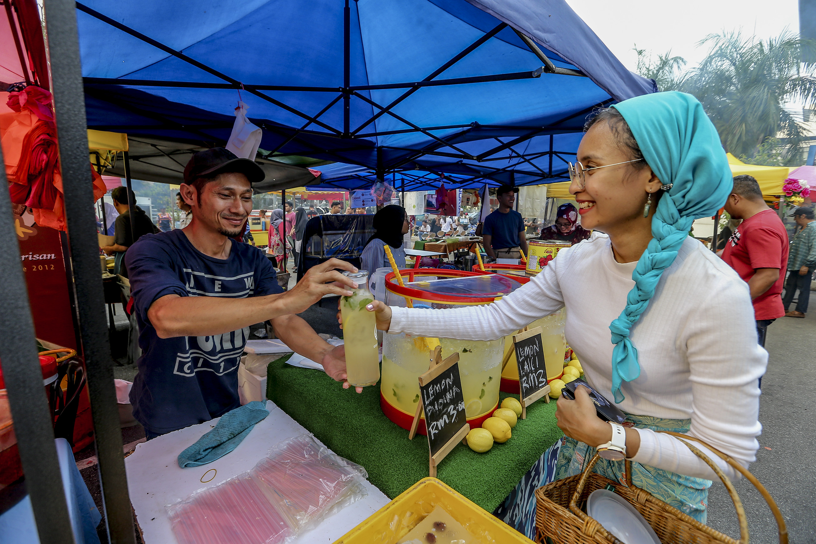 Amalina says ‘no thank you’ to 'ikat tepi' packaging by bringing her own bottle when buying drinks at the bazaar. — Picture by Firdaus Latif