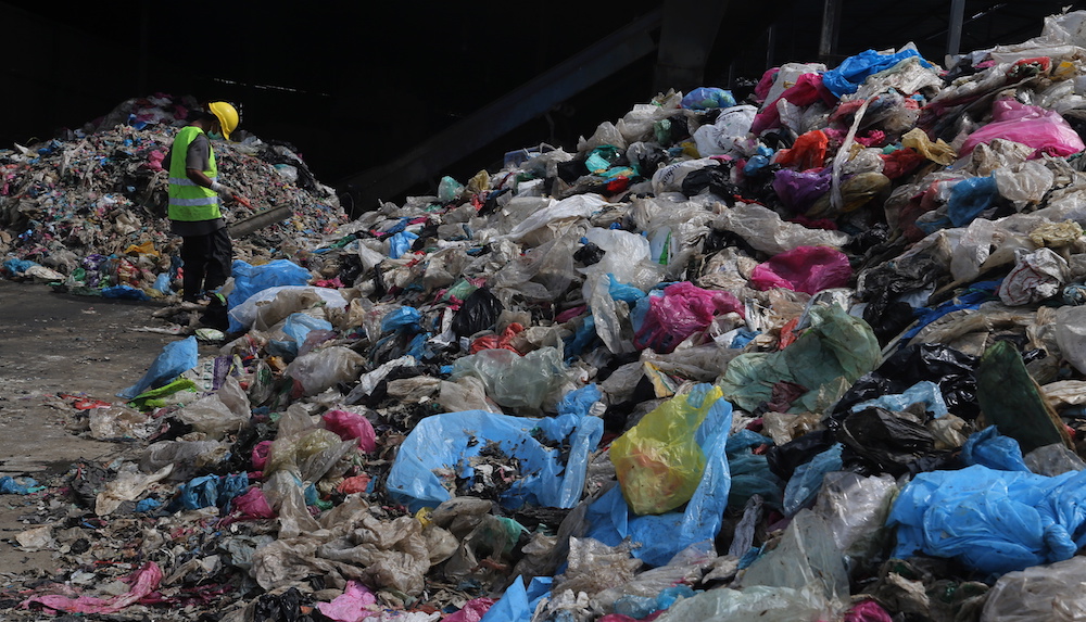 A worker sorts through garbage at the Pulau Burung landfill in Nibong Tebal, Penang. u00e2u20acu201d Picture by Sayuti Zainudin
