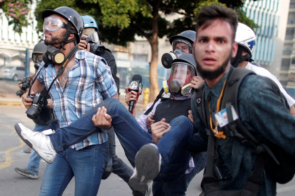 An injured member of the media (centre) is carried away during a rally against the government of Venezuela's President Nicolas Maduro and to commemorate May Day in Caracas May 1, 2019. u00e2u20acu201d Reuters pic