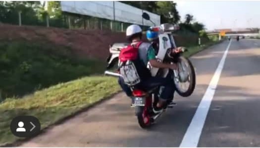 Muhammad Shah Raziq Mohd Salleh rides his motorcycle as his friend rides pillion...while holding on to another motorcycle. u00e2u20acu201d Screen capture via Instagram/muhdshziq