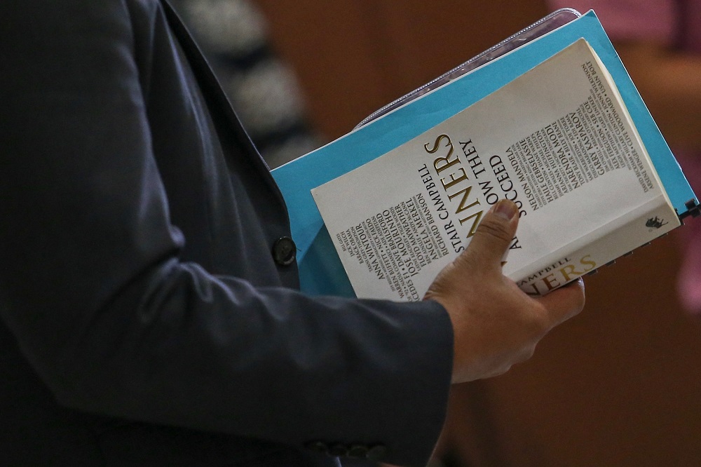 The book ‘Winners and How They Succeed’ by Alastair Campbell is seen being held by one of Datuk Seri Najib Razak’s aides at the Kuala Lumpur Court Complex May 9, 2019 — Picture by Hari Anggara