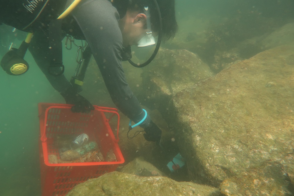 A diver retrieves a can while cleaning up the waters of Lazarus Island of marine debris. — Our Singapore Reefs via TODAY