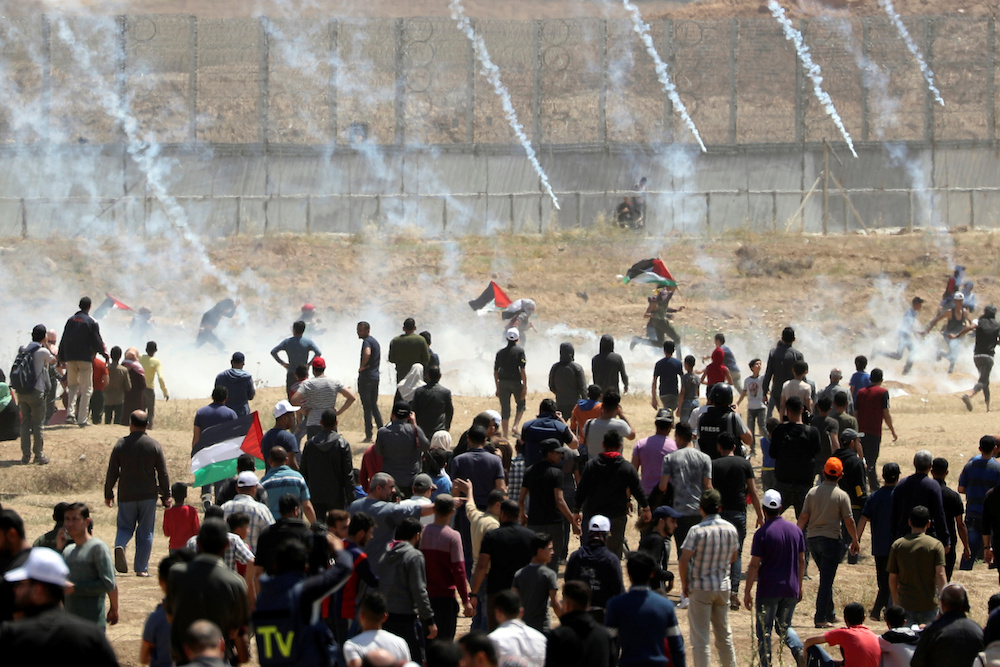 Palestinian demonstrators run for cover from tear gas canisters fired by Israeli forces during a protest marking the 71st anniversary of the 'Nakba' east of Gaza City May 15, 2019. u00e2u20acu201d Reuters picn n