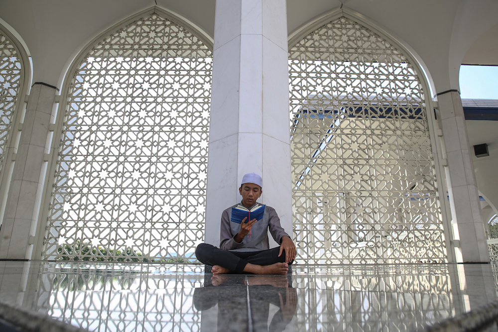 A boy recites the Quran at Sultan Salahuddin Abdul Aziz Shah Mosque in Shah Alam May 22, 2019. u00e2u20acu201d Picture by Yusof Mat Isa