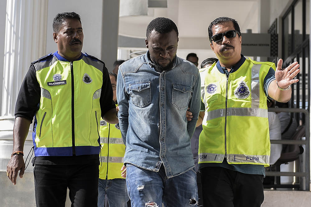 Alowonlw Oluwajuwon Gilbert, the suspect in the murder of Serdang Hospital chief nurse Siti Kharina Mohd Kamarudin, is led to the Magistrate Court in Sepang May 27, 2019. u00e2u20acu201d Picture by Miera Zulyana