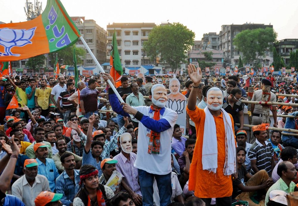 Indian political supporters of Bharatiya Janata Party (BJP) wave a party flag as they wear masks of Prime Minister Narendra Modi during an election campaign led by Modi in Kolkata on May 16, 2019. u00e2u20acu201d AFP pic