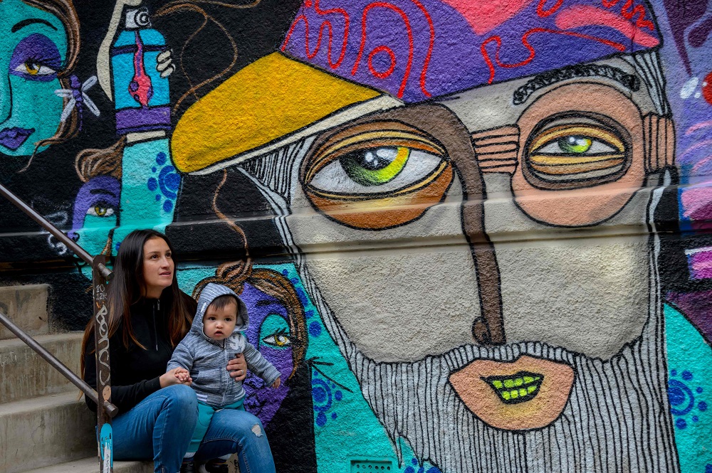 Chilean artist Cynthia Aguilera poses with her son next to a mural made by her in Valparaiso, Chile April 9, 2019. — AFP pic
