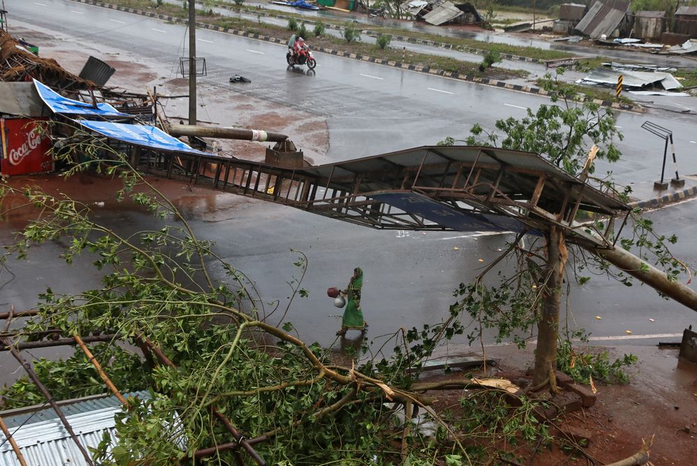 A woman carries pitchers next to uprooted trees and a fallen signboard following Cyclone Fani in Khordha district in the eastern state of Odisha, India, May 3, 2019. u00e2u20acu201d Reuters pic