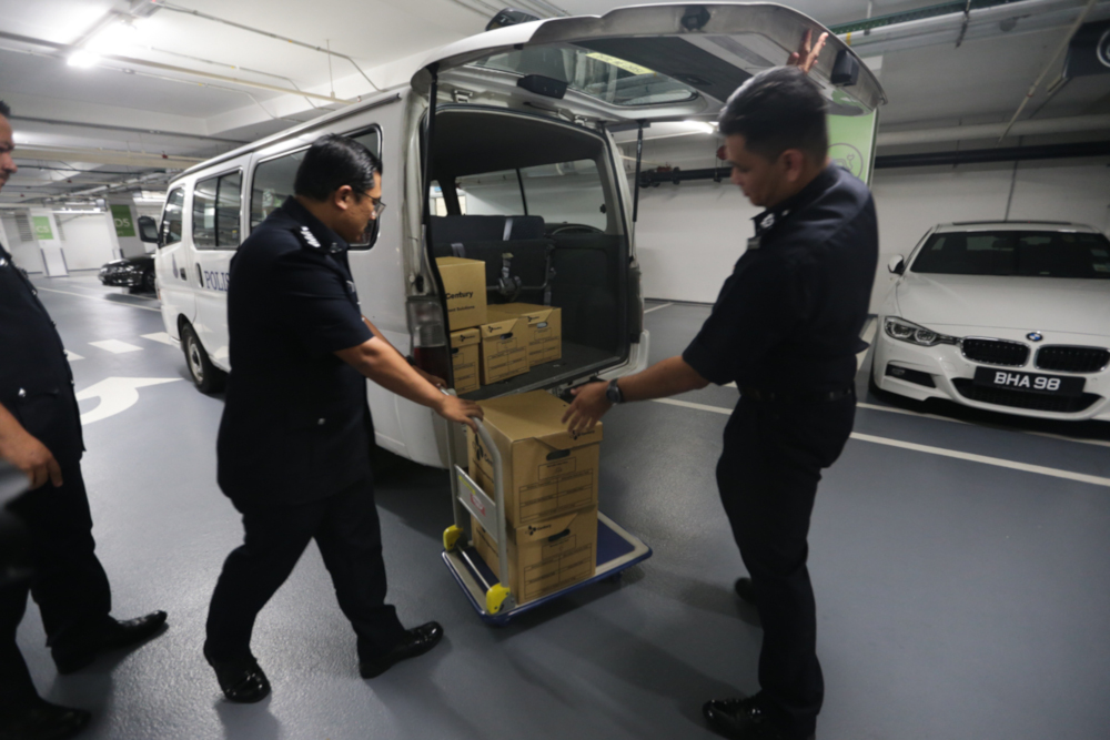 Officers from Bukit Aman’s Commercial Crimes Investigation Department (CCID) placing boxes into a van at the Deloitte head office in Taman Tun Dr Ismail May 23, 2019. — Picture by Ahmad Zamzahuri