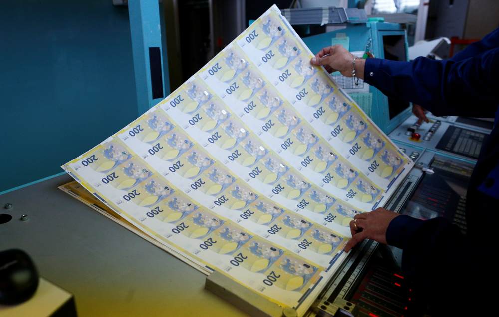 A worker manages sheets of the new u00e2u201au00ac200 banknotes in the secretive vaults inside the Bank of Italy, in Rome May 21, 2019. u00e2u20acu2022 Reuters pic