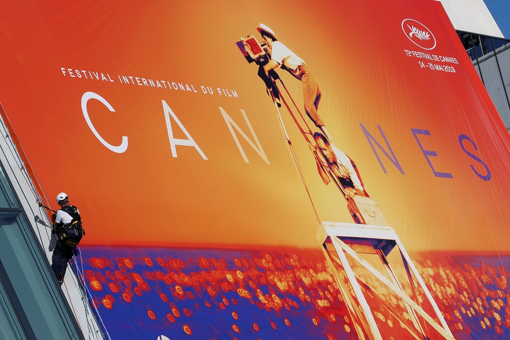 A worker is seen near a giant canvas of the official poster on the facade of the festival palace for the 72nd Cannes Film Festival in Cannes France May 12, 2019. u00e2u20acu201d Reuters pic      