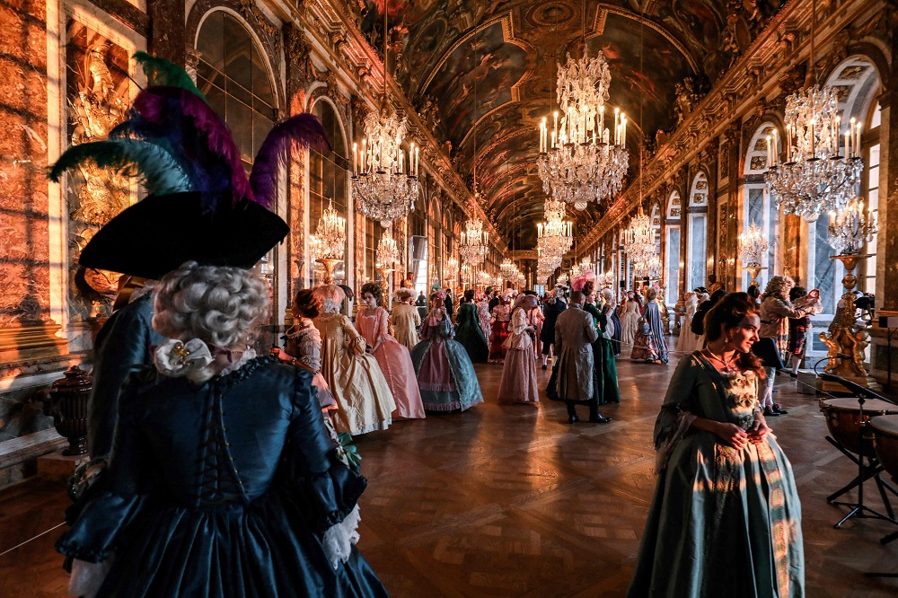 People dressed in period costumes take part in the ‘Fetes Galantes’ fancy dress evening at the ‘galerie des glaces’ in the Chateau de Versailles May 27, 2019. — AFP pic