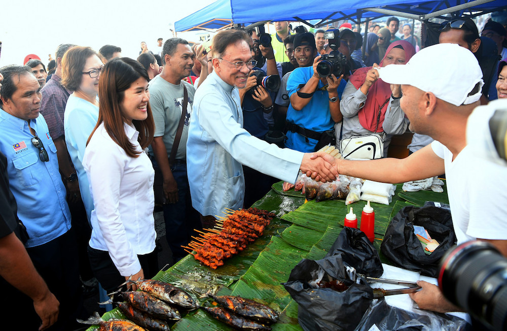 Datuk Seri Anwar Ibrahim meets traders at a Ramadan bazaar in Sandakan May 7, 2019, during a walkabout with DAPu00e2u20acu2122s candidate Vivian Wong for the constituencyu00e2u20acu2122s upcoming by-election. u00e2u20acu201d Bernama pic