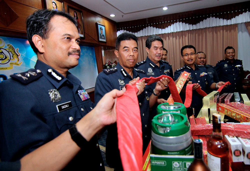 Johor Royal Malaysian Customs Department director Datuk Mohammad Hamidan Maryani (2nd left) poses with the seized contraband during a press conference in Johor Baru May 7, 2019. u00e2u20acu201d Bernama pic
