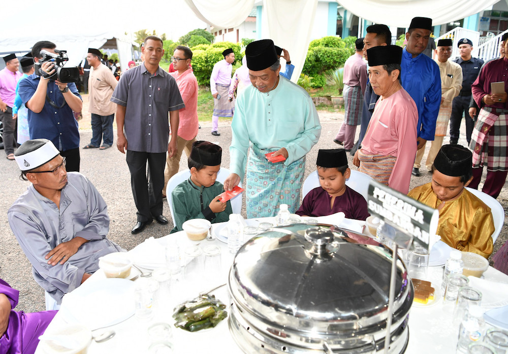 Tan Sri Muhyiddin Yassin gives u00e2u20acu02dcduit rayau00e2u20acu2122 to orphans during a gathering at Masjid Jamek Nurul Yakin, Gugusan Felda Maokil in Muar May 17, 2019. u00e2u20acu201d Bernama pic