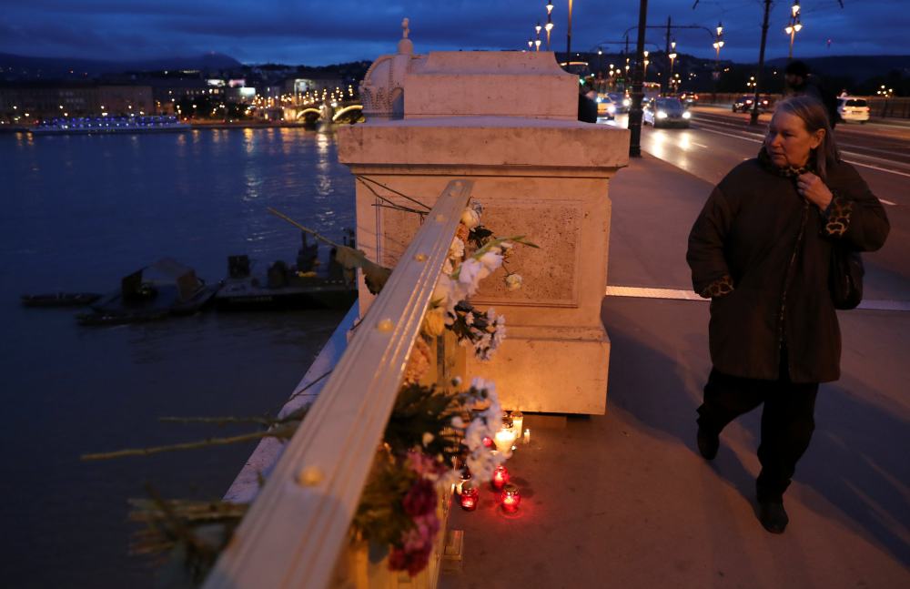A woman walks past flowers and burning candles on the Margaret Bridge near the site of a ship accident, which killed several people, on the Danube river in Budapest May 30, 2019. u00e2u20acu2022 Reuters pic 