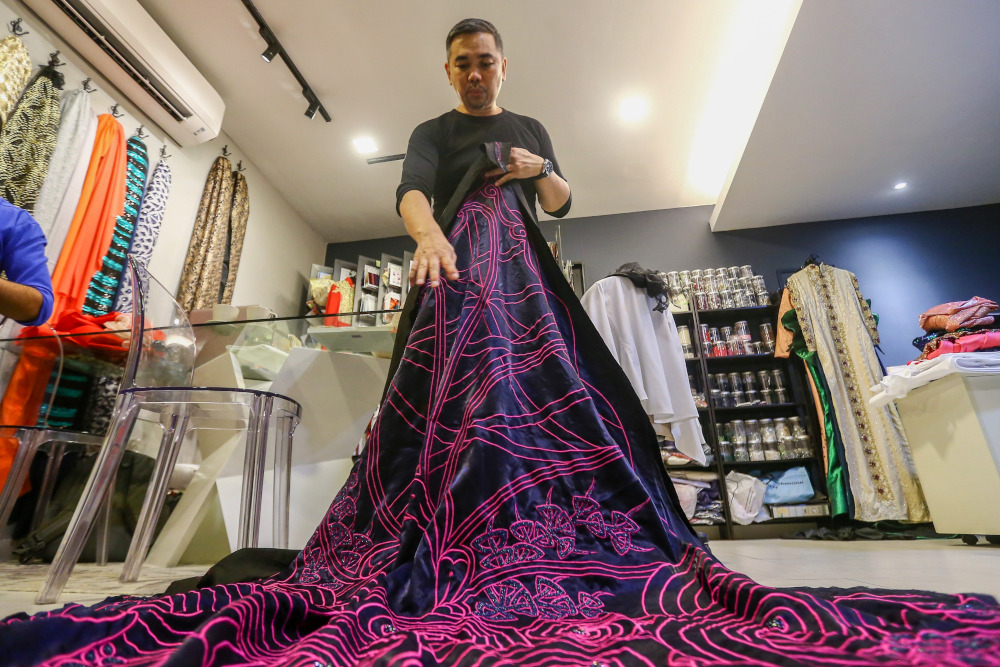 KL Ho showing off the zentagle patterned material made for one of his designs. — Picture by Hari Anggara