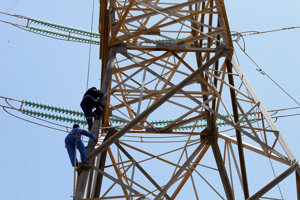 Workers operate on high voltage towers after they were damaged by fightings, south of Tripoli, Libya May 23, 2019. u00e2u20acu201d AFP pic           