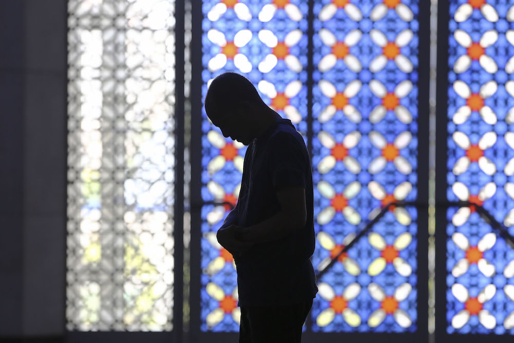 The silhouette of a man as he prays during the holy month of Ramadan at the Sultan Salahuddin Abdul Aziz Shah Mosque in Shah Alam, May 18, 2019. u00e2u20acu201d Yusof Mat Isann
