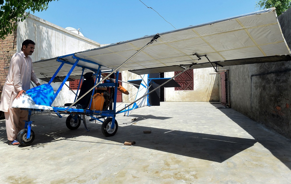 In this picture taken on April 8, 2019, Pakistani villager Muhammad Fayyaz stands alongside his small plane at his residence in Tabur village in central Punjab province. u00e2u20acu201d AFP pic  
