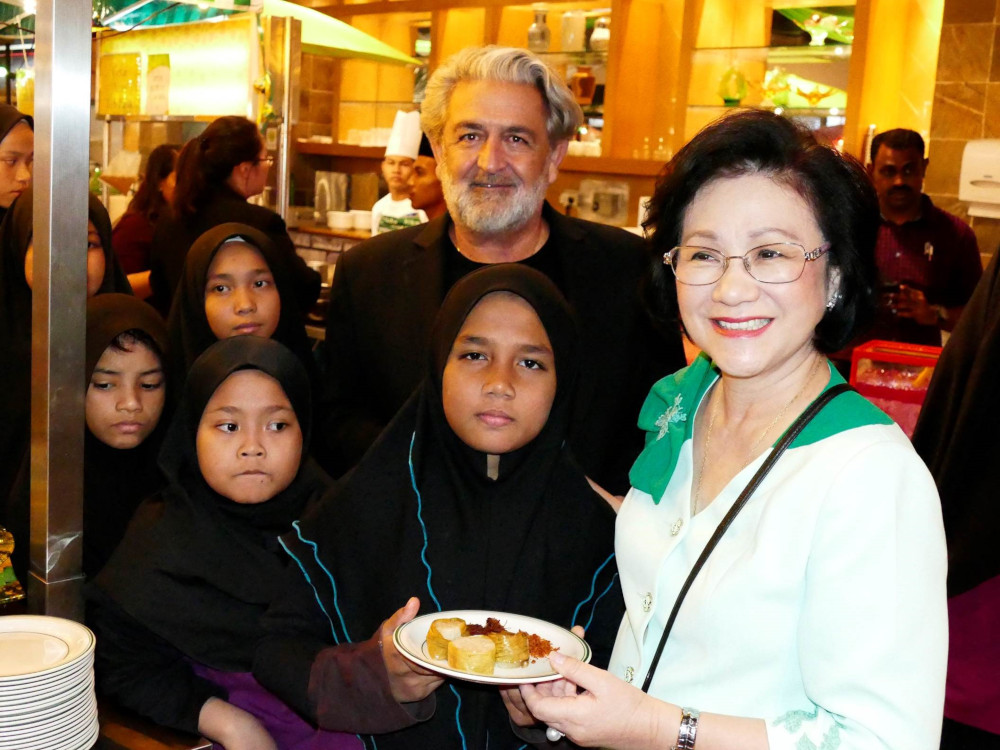 Genting Malaysia CEO and Chairman of Hospitality’s wife, Puan Seri Cecilia Lim and Executive Vice-President of Leisure and Hospitality, Datuk Edward Holloway pose for a picture with some of the children during the breaking of fast event at Rajawali Coffee House, Awana Hotel. — Picture courtesy of Resorts World Genting