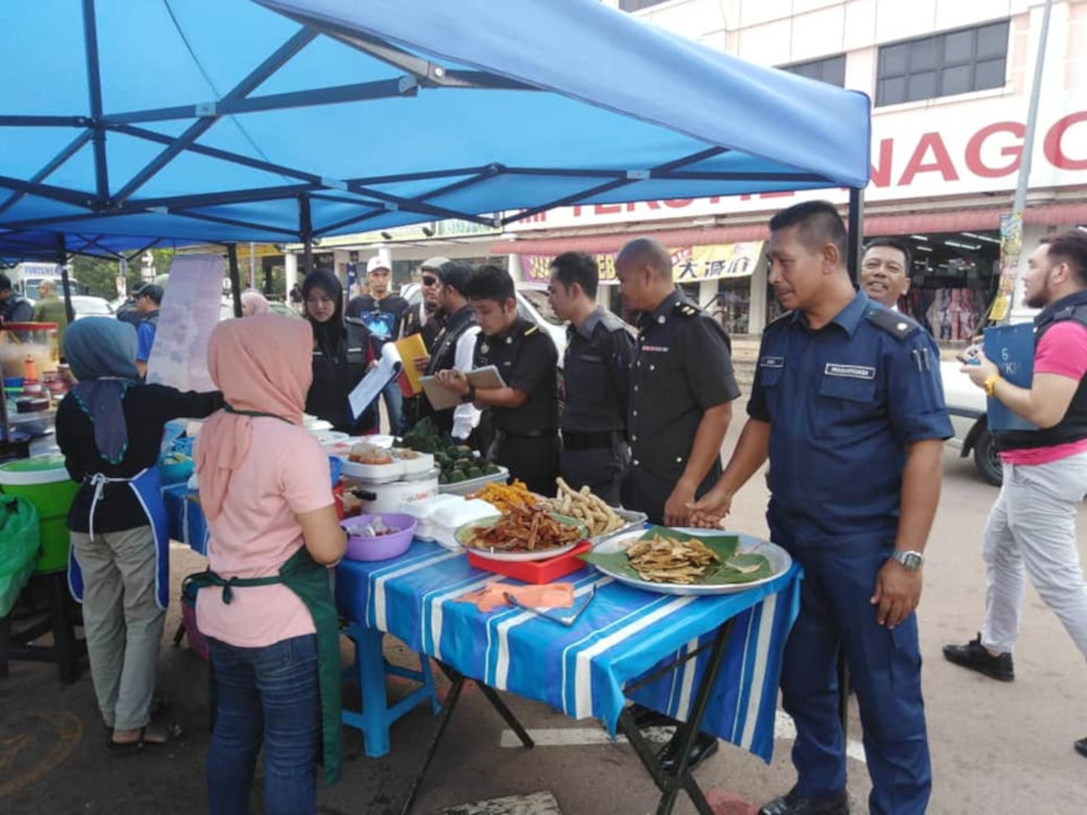 Segamat Municipal Council personnel conducting checks on a food stall May 15, 2019. u00e2u20acu201d Picture from Facebook/Majlis Perbandaran Segamat 
