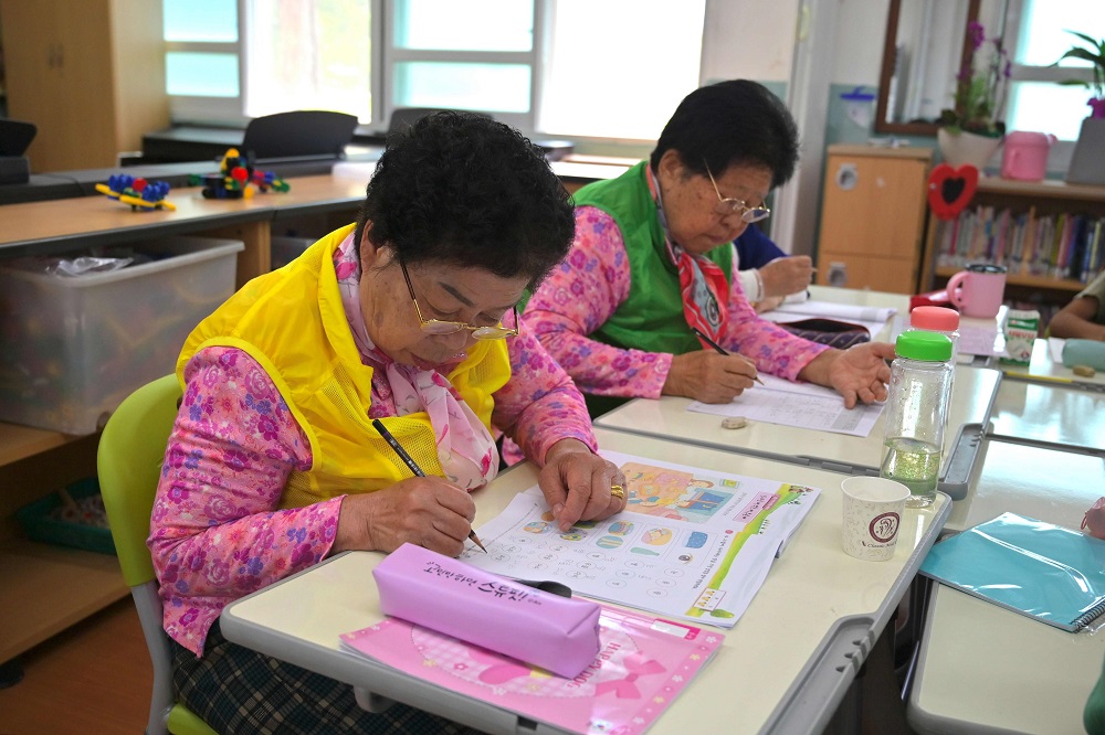 This picture taken on May 15, 2019 shows elderly South Korean women Park Young-ae (left) and Nam Yang-soon taking a spelling test in a classroom at Woldeung Elementary School on the outskirts of Suncheon. u00e2u20acu2022 AFP pic         
