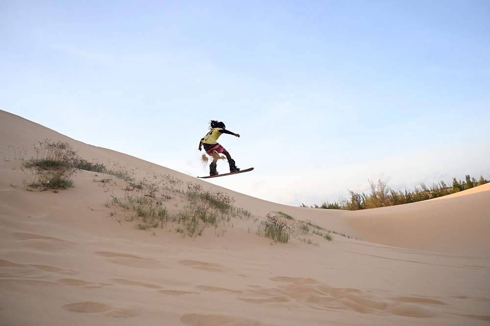 This photograph taken on April 24, 2019 shows Nguyen Thai Binh riding down sand dunes on his snowboard in the southern Vietnamese town of Mui Ne. u00e2u20acu201d AFP pic   