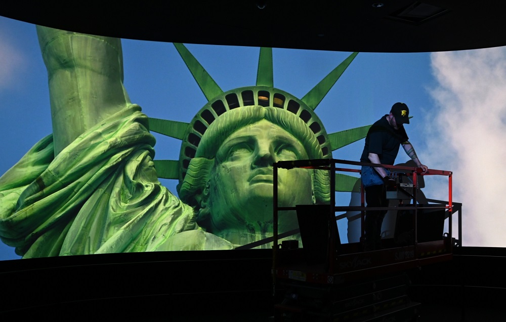 A worker puts finishing touches on the ceiling in a room showing a movie during a press preview at the new Statue of Liberty Museum May 13, 2019. u00e2u20acu201d AFP pic