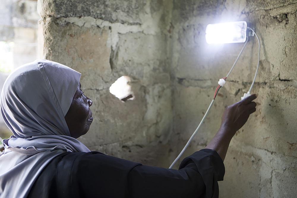Amina Shamata, a teacher at Barefoot College, Zanzibar, installs a solar light in a home in Knyasini Bondini village, Zanzibar 24 October 2018. u00e2u20acu201dThomson Reuters Foundation 