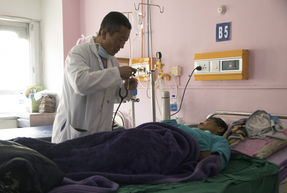 In this photo taken on March 30, 2019, Bhutanu00e2u20acu2122s Prime Minister Lotay Tshering treats a patient at the National Referral Hospital in the Bhutanese capital Thimphu. u00e2u20acu201d AFP pic