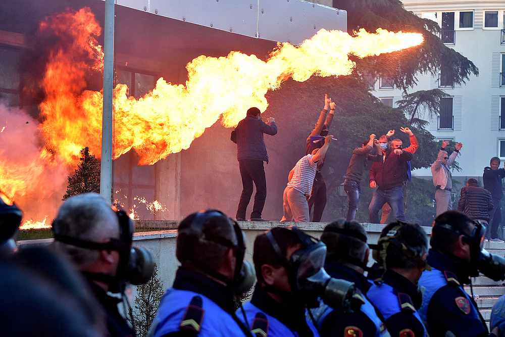 Flames are pictured behind a police formation during an anti-government protest in front of Prime Minister Edi Rama's office in Tirana, Albania May 11, 2019. u00e2u20acu201d Reuters pic