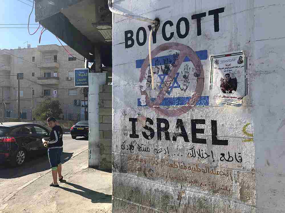 A Palestinian boy looks on near a graffiti boycotting Israel in Bethlehem, in the Israeli-occupied West Bank November 3, 2018. u00e2u20acu201d Reuters pic