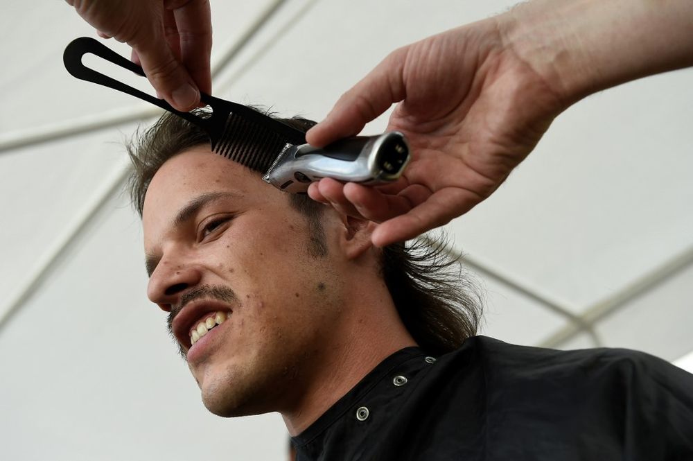 A man has his hair cut during the mullet haircut festival in Boussu, Belgium on May 18 2019. u00e2u20acu201d AFP pic
