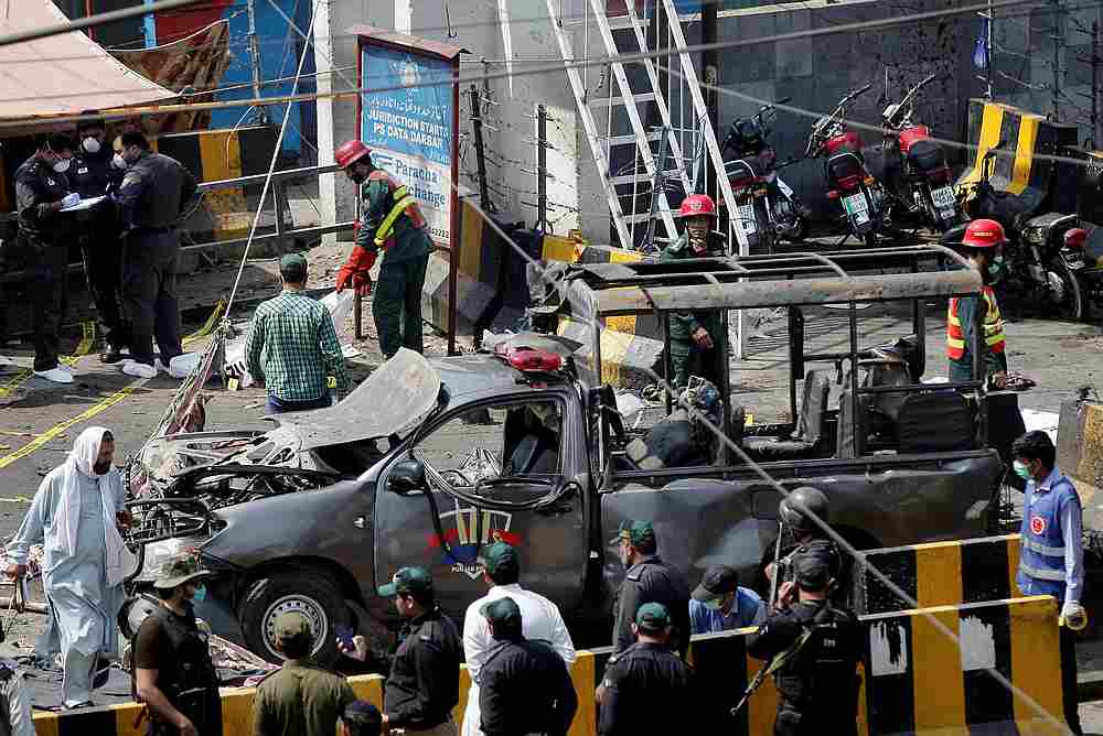 Police officers survey while rescue workers attend to a body at the site of a blast in Lahore, Pakistan May 8, 2019. u00e2u20acu201d Reuters pic