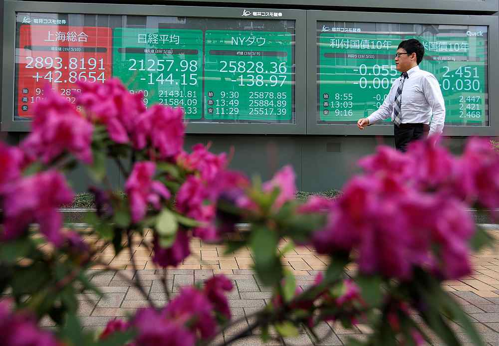 A passerby in front of a stock quotation board outside a brokerage in Tokyo, Japan May 10, 2019. u00e2u20acu201d Reuters pic