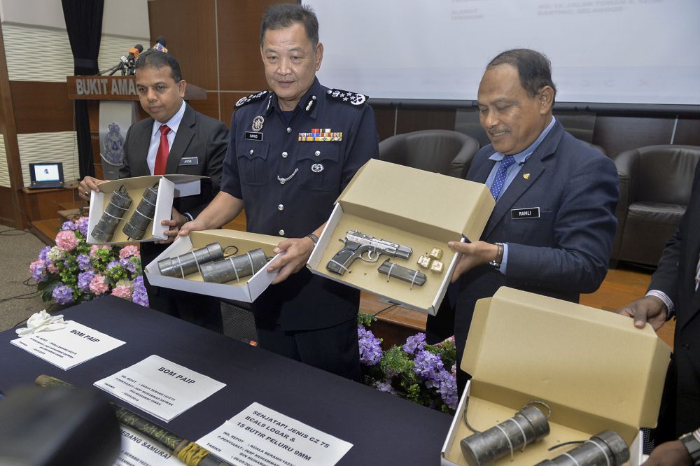 Inspector-General of Police Datuk Seri Abdul Hamid Bador (centre) holds up items seized during anti-terrorism raids in a press conference at the Bukit Aman police headquarters in Kuala Lumpur May 13, 2019. u00e2u20acu201d Picture by Mukhriz Hazim