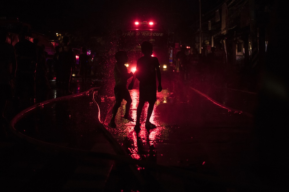 In this file photo taken on May 23, 2018, children play as a fire engulfs a slum area in Manila. u00e2u20acu201d AFP pic        