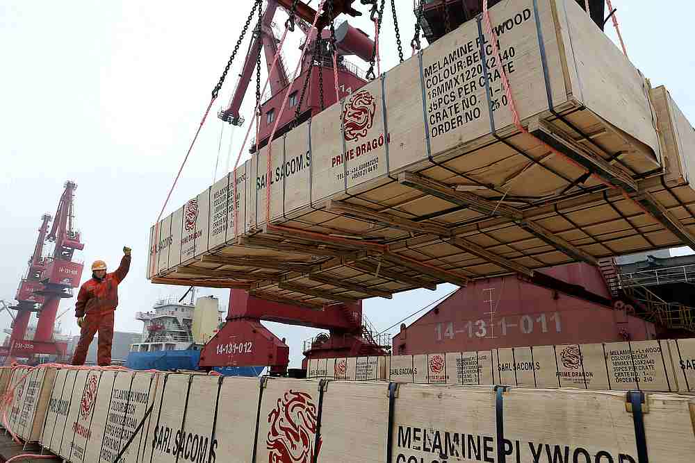 A worker gestures as a crane lifts goods for export onto a cargo vessel at a port in Lianyungang, Jiangsu province, China February 13, 2019. u00e2u20acu201d Reuters pic