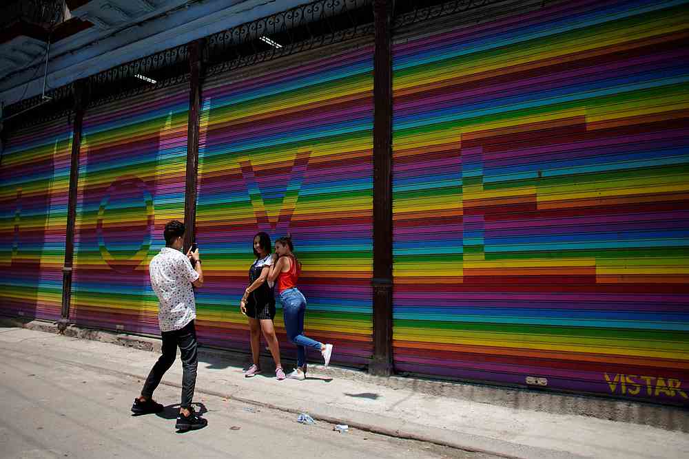 People pose for photos in front of a painting with the colours of the rainbow flag in Havana, Cuba, May 7, 2019. u00e2u20acu201d Reuters pic