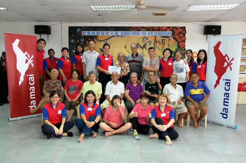 Rumah Sejahtera Seri Kembangan executive secretary Thong Sing Foo (centre, right) receives the contribution from Da Ma Cai volunteer Yee Kiat Wah. u00e2u20acu201d Picture courtesy of Da Ma Cai