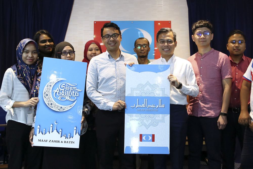 PKR communication director Fahmi Fadzil (third from right) and treasurer-general Lee Chean Chung (centre) pose with mock u00e2u20acu02dcduit rayau00e2u20acu2122 envelopes at the partyu00e2u20acu2122s headquarters in Petaling Jaya May 9, 2019. u00e2u20acu201d Picture by Yusof Mat Isa