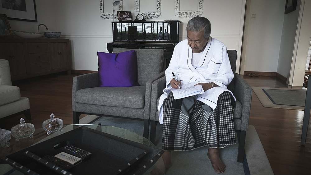 Tun Dr Mahathir Mohamad going through a draft speech in his dressing gown before the election day. — Picture courtesy of 'M for Malaysia'
