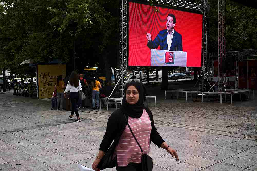A woman walks past the European Union elections kiosk of ruling Syriza party as a screen displays a speech of Greek Prime Minister Alexis Tsipras in Athens May 14, 2019. u00e2u20acu201d Reuters pic