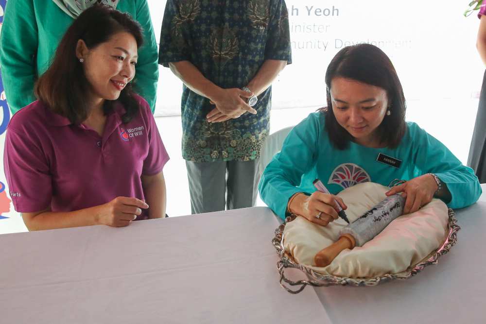 Hannah Yeoh writes on a rolling pin during the launch of the Women of Will's Community Kitchen in Kuala Lumpur May 25, 2019.