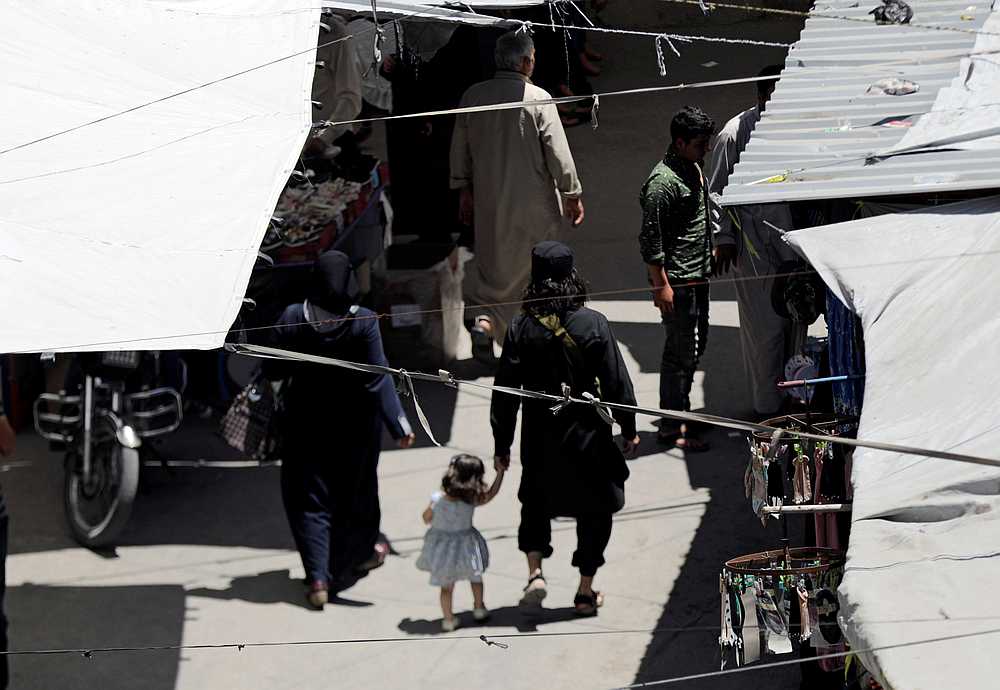 A man with a gun holds the hand of a child as they walk in a souk in the city of Idlib, Syria May 25, 2019. u00e2u20acu201d Reuters pic