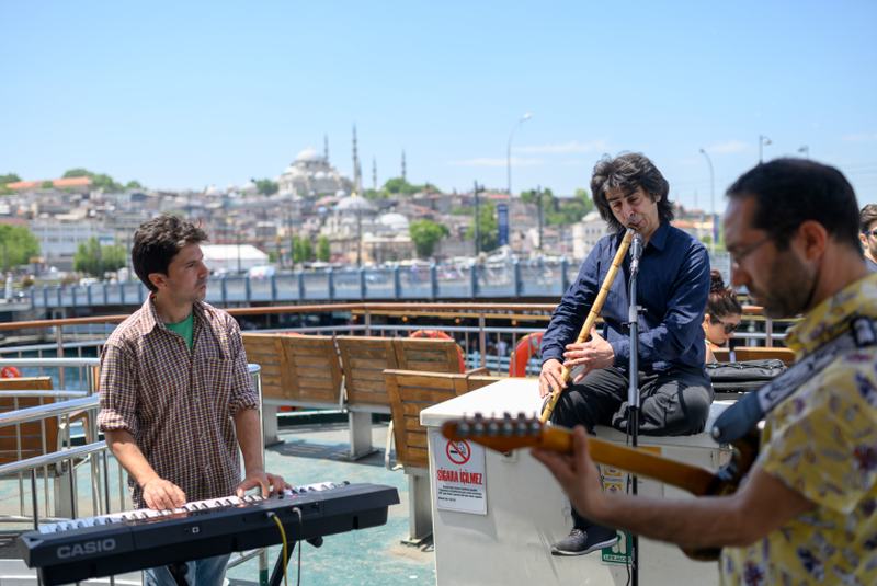 Musicians Oguzhan Erdem (centre) plays ney, Eren Koc (left) keyboard and Zafer Saka (right) guitar during a ferry trip on the Bosphorus. u00e2u20acu2022 AFP pic
