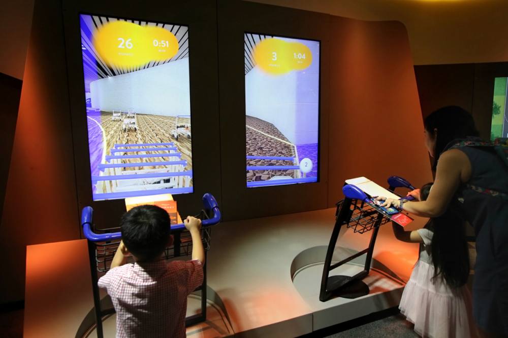 Visitors play a game simulating the job of a trolley handler at the Changi Experience Studio. ― Picture by Nuria Ling via TODAY