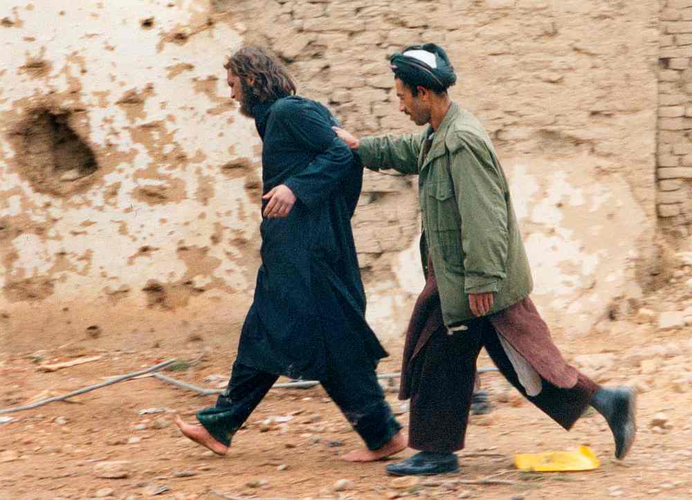 US-born John Walker Lindh (left) is led away by a Northern Alliance soldier after he was captured following an uprising at the Fort Qali-i-Janghi prison near Mazar-i-Sharif December 1, 2001. u00e2u20acu201d Reuters pic